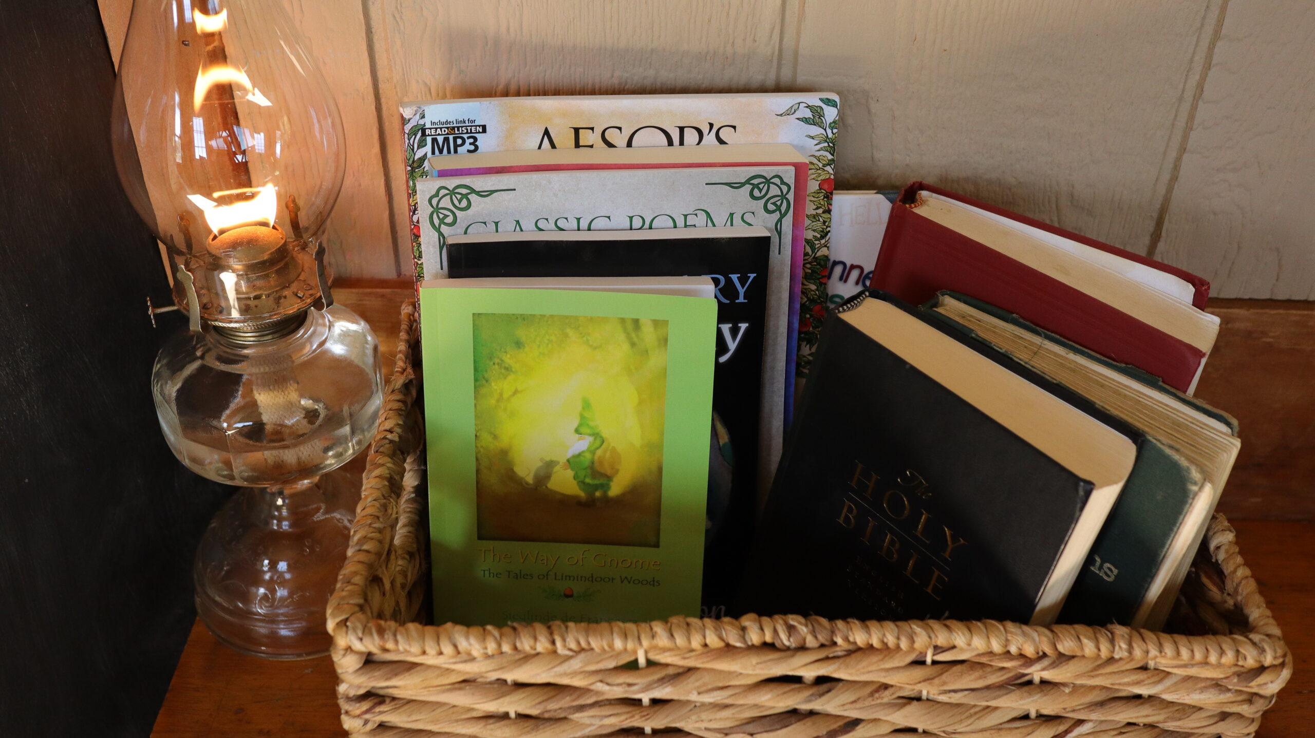 basket of books next to lit oil lamp