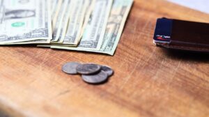 Fanned out cash and coins with wallet on counter top